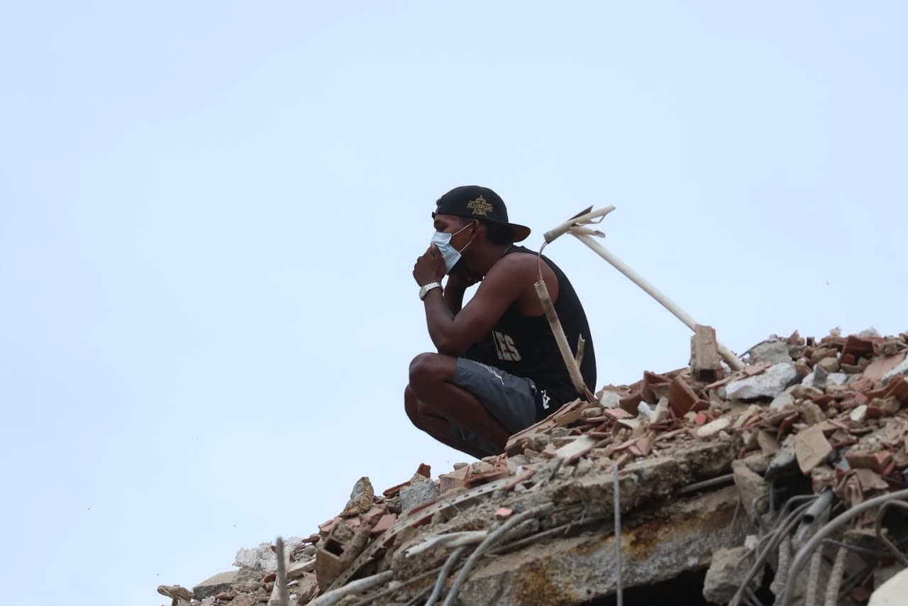 Rescatista civil reposa en la cima de los escombros de su edifico. Foto: José Altuve